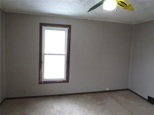 empty room featuring ceiling fan, baseboards, and a textured ceiling