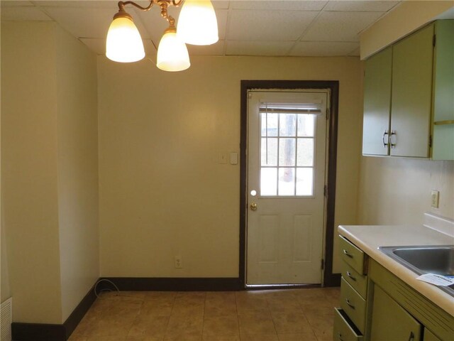 entryway featuring light tile patterned flooring, sink, a paneled ceiling, and a notable chandelier