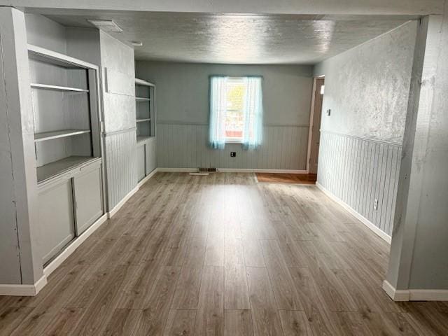 interior space with wood-type flooring and a textured ceiling