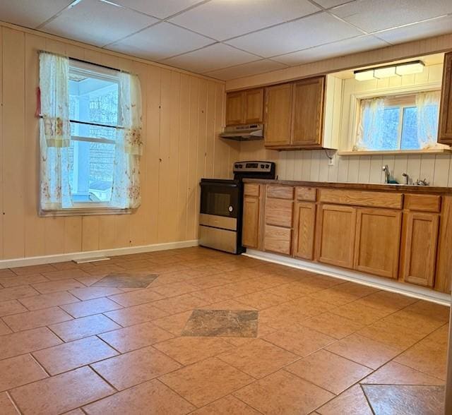 kitchen with electric stove, a paneled ceiling, and wooden walls