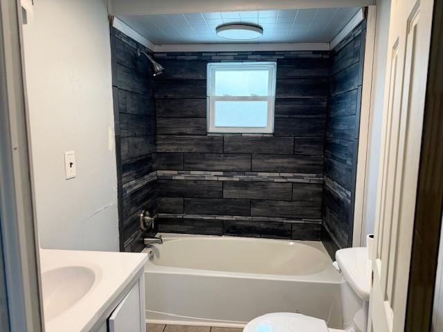 full bathroom with vanity, tiled shower / bath combo, and toilet