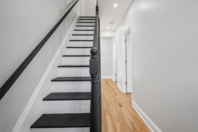 stairs featuring hardwood / wood-style floors