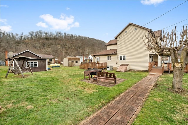 view of yard featuring a storage unit and a deck