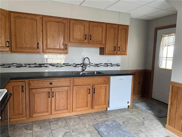 kitchen with tasteful backsplash, sink, range, white dishwasher, and a drop ceiling