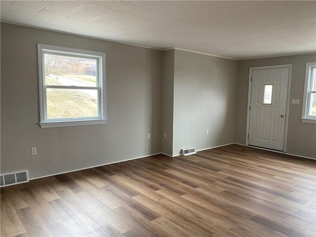 entryway with hardwood / wood-style flooring and crown molding