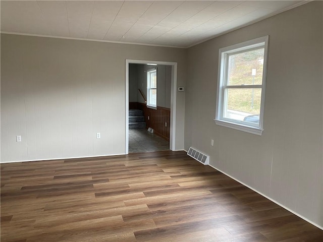 spare room featuring hardwood / wood-style flooring and ornamental molding