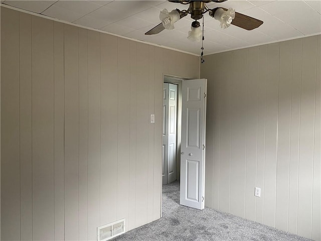 carpeted empty room with ceiling fan and ornamental molding