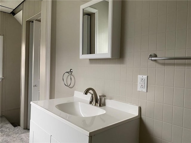 bathroom featuring vanity and tile walls