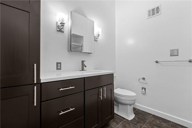 bathroom featuring vanity, tile patterned floors, and toilet