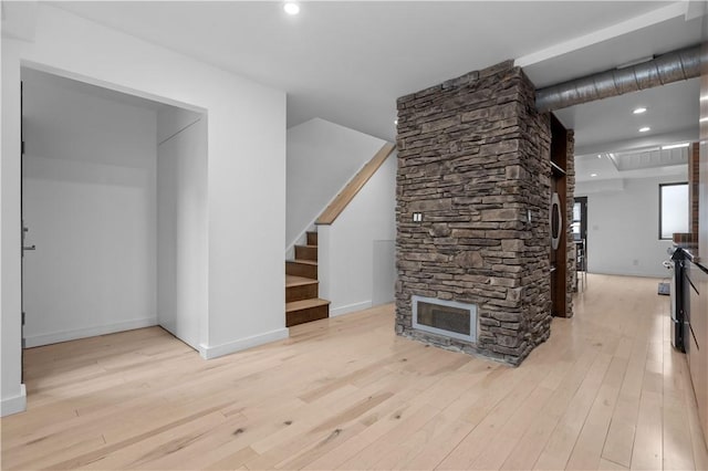 unfurnished living room with a fireplace and light hardwood / wood-style floors