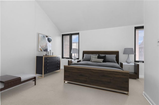 bedroom with light colored carpet, vaulted ceiling, and multiple windows