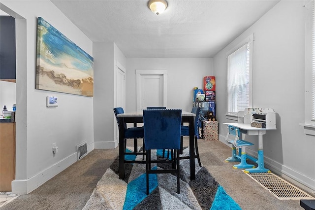 dining room with a textured ceiling and carpet flooring