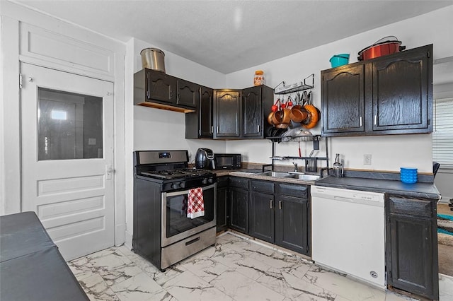 kitchen featuring dishwasher, sink, stainless steel range with gas stovetop, and a textured ceiling