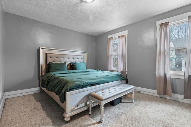 bedroom featuring multiple windows, carpet flooring, and a textured ceiling