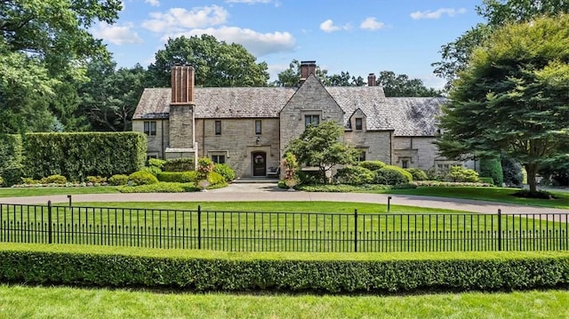 tudor-style house with a front yard