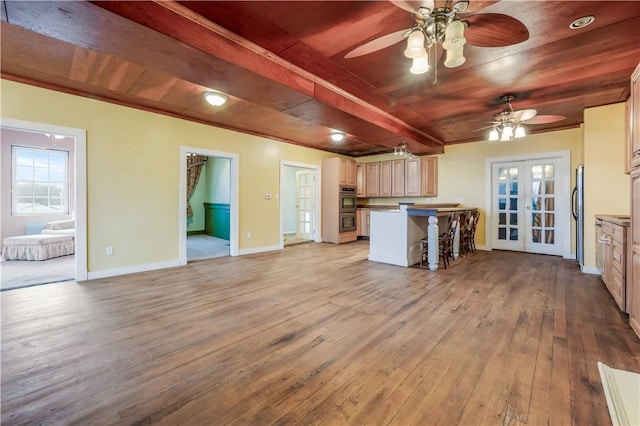 kitchen featuring a breakfast bar area, appliances with stainless steel finishes, wooden ceiling, french doors, and light wood-type flooring