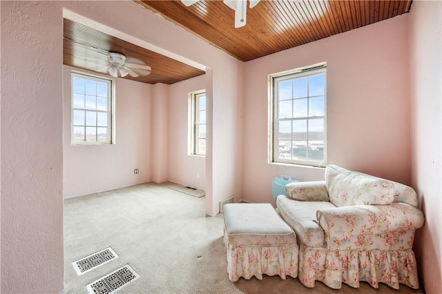 sitting room with ceiling fan, plenty of natural light, light carpet, and wooden ceiling