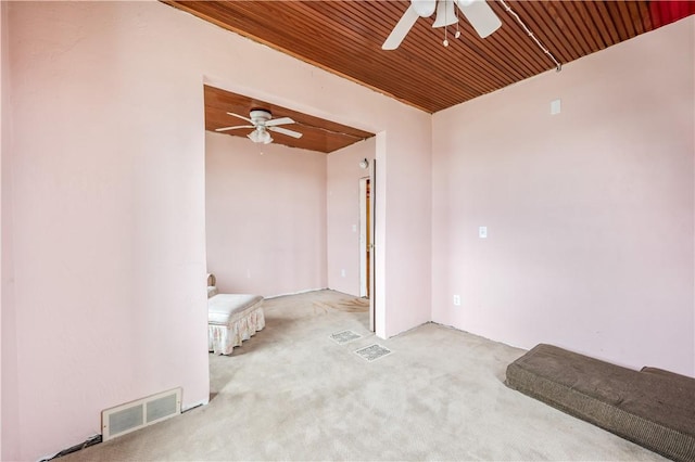 carpeted spare room with ceiling fan and wooden ceiling