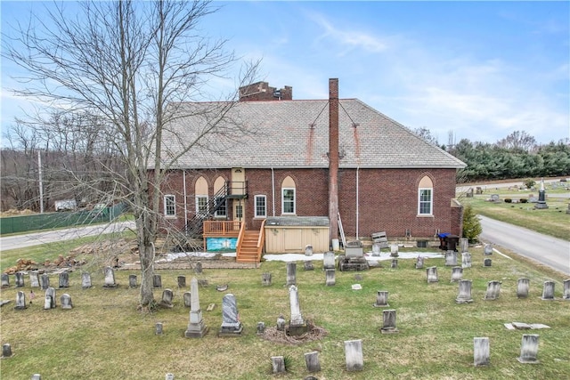 back of property featuring a yard and a deck