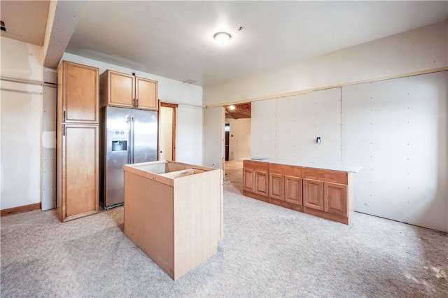 kitchen featuring a kitchen island, light carpet, and stainless steel fridge