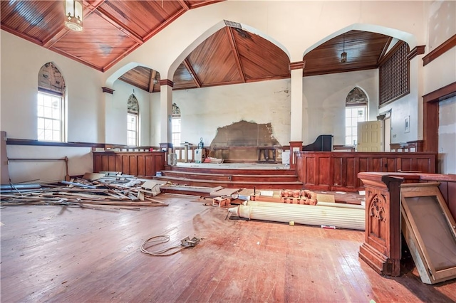 miscellaneous room with ornamental molding, wood-type flooring, high vaulted ceiling, and wooden ceiling