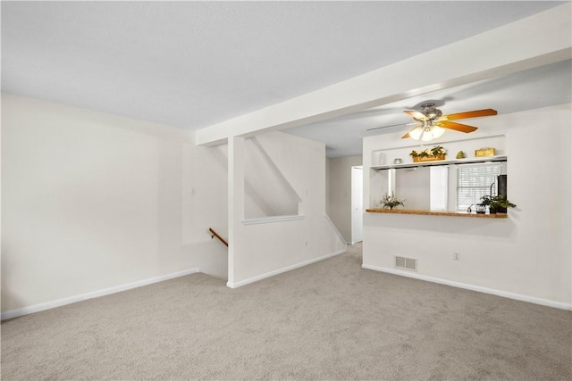 unfurnished living room featuring ceiling fan, beamed ceiling, and carpet