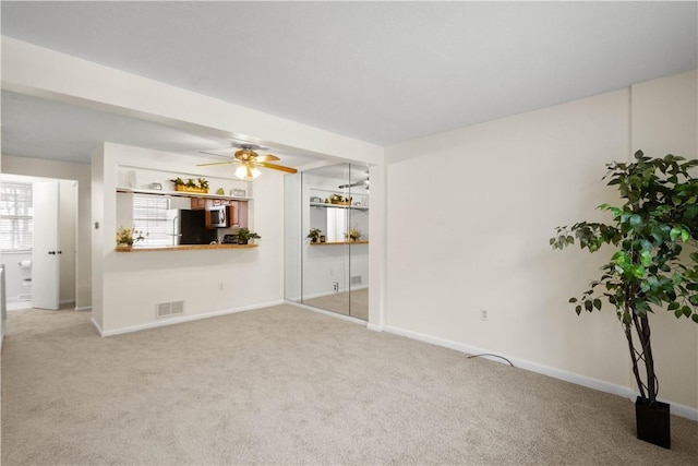 unfurnished living room with ceiling fan and carpet floors