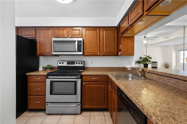 kitchen featuring sink, light tile patterned floors, ceiling fan, appliances with stainless steel finishes, and kitchen peninsula