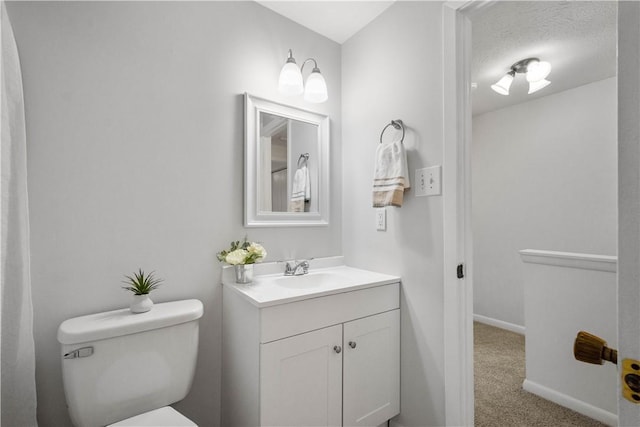 bathroom with vanity, a textured ceiling, and toilet