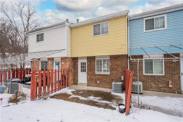 snow covered house featuring central AC