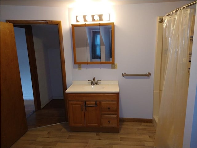 bathroom with hardwood / wood-style flooring, vanity, and walk in shower