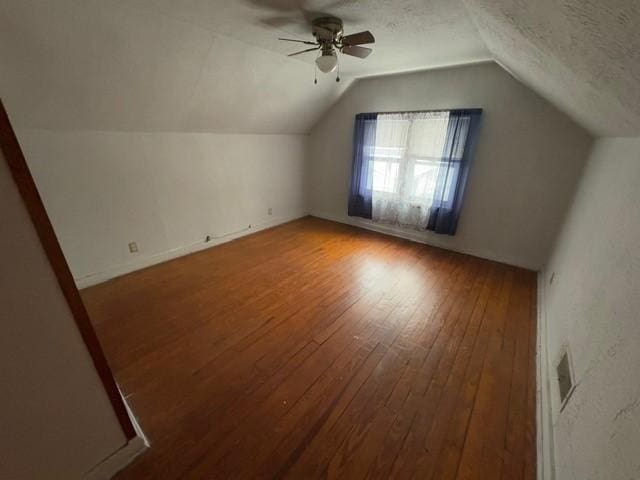 bonus room featuring lofted ceiling, ceiling fan, wood-type flooring, and a textured ceiling