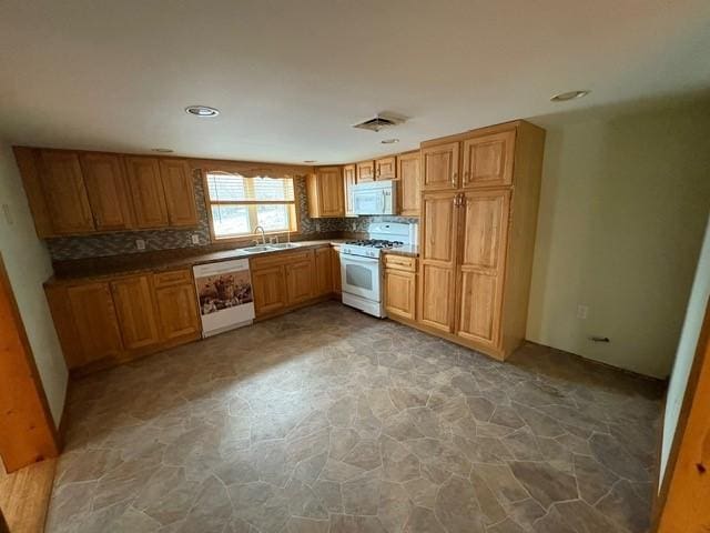 kitchen with sink, white appliances, and backsplash