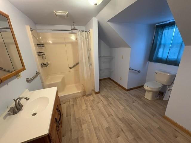 bathroom featuring a shower with curtain, wood-type flooring, toilet, and vanity