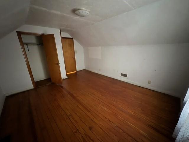 bonus room with lofted ceiling and dark hardwood / wood-style floors
