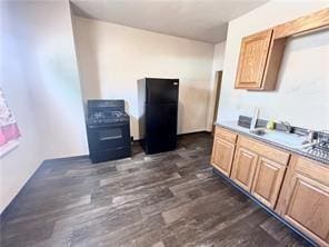 kitchen with black refrigerator, sink, and dark hardwood / wood-style floors