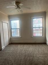 interior space with ceiling fan and ornamental molding