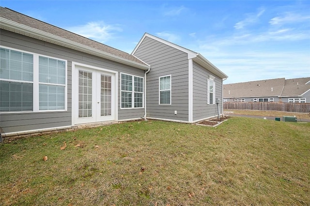 rear view of house with a yard and french doors