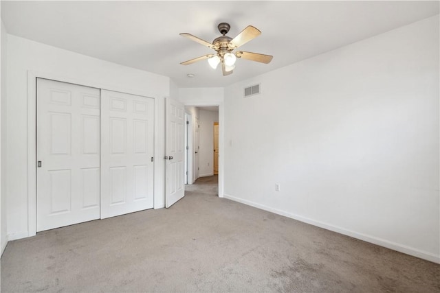 unfurnished bedroom with light carpet, a closet, and ceiling fan