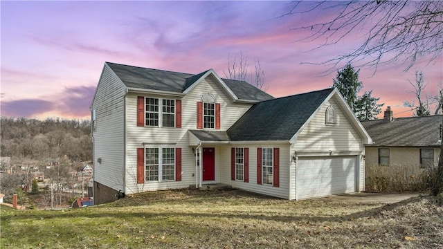 view of front of home with a garage and a lawn