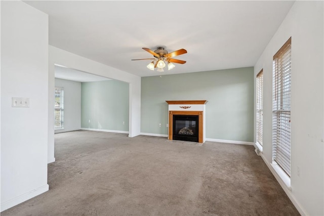 unfurnished living room with ceiling fan and carpet