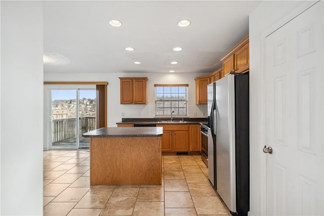 kitchen featuring stainless steel fridge with ice dispenser, sink, a wealth of natural light, and a center island