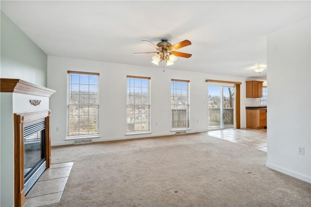 unfurnished living room with ceiling fan and light colored carpet