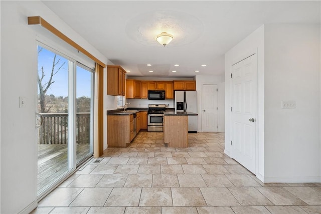 kitchen with stainless steel appliances, a kitchen island, and sink