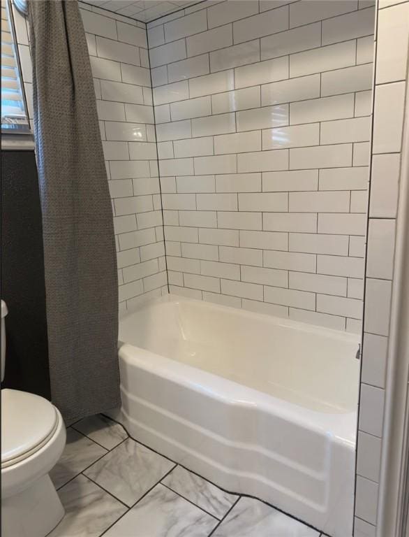 bathroom with tiled shower / bath combo and toilet