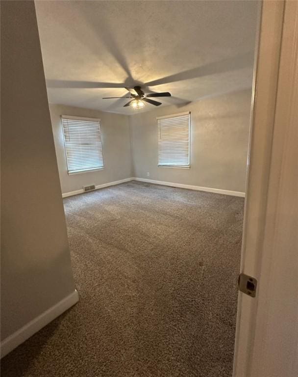 carpeted empty room featuring ceiling fan