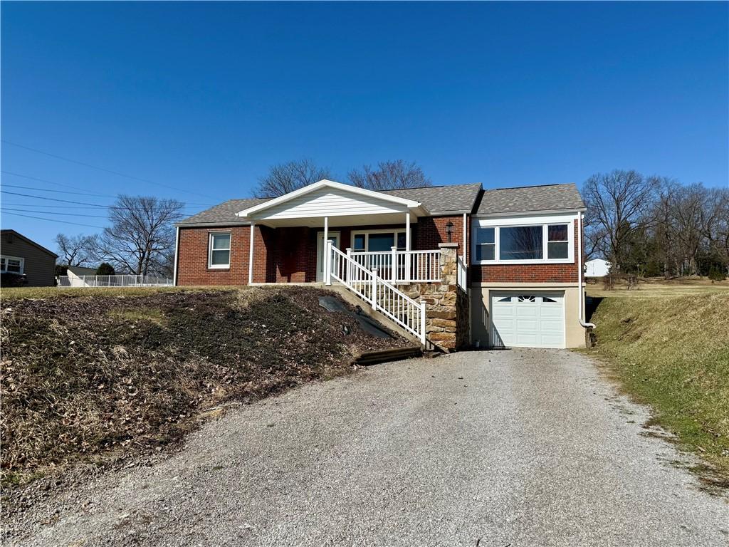 1510 Butler Rd, West Franklin, PA 16262 - ranch-style house with covered porch, a garage, gravel driveway, and brick siding