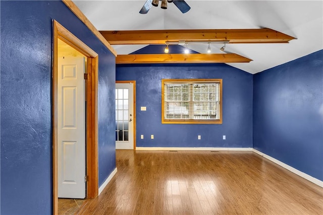 empty room with ceiling fan, wood-type flooring, and lofted ceiling with beams