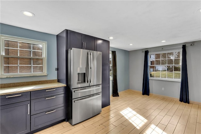 kitchen with stainless steel fridge with ice dispenser and light wood-type flooring