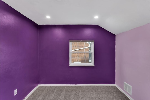 carpeted empty room featuring lofted ceiling